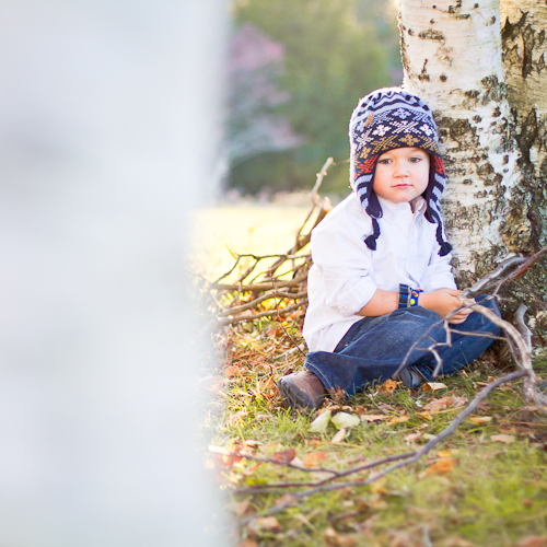 Boy in hat under birch tree